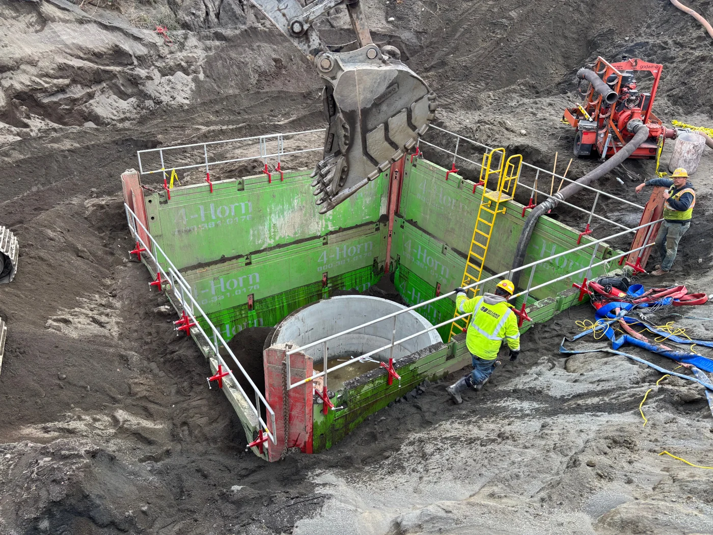 LES guardrail and yellow access ladder installed around a trench box on an active jobsite