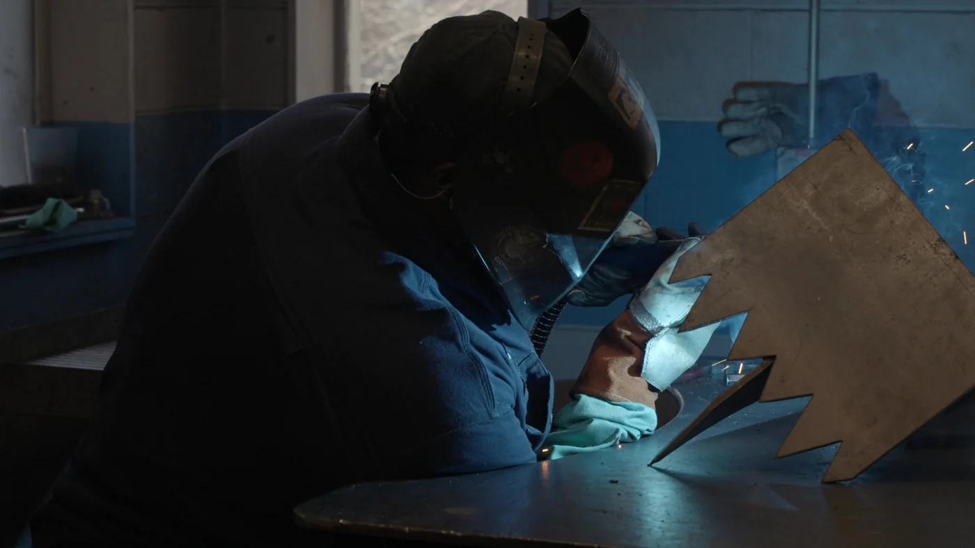 A welder working on a steel component at AES